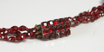 Lot 565 - An antique garnet three strand necklace, with...