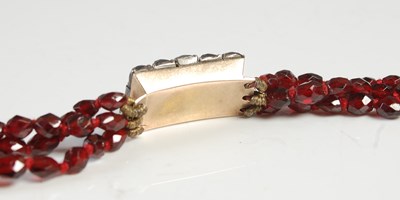 Lot 565 - An antique garnet three strand necklace, with...