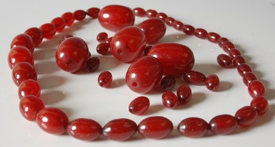 Lot 547 - A red amber type graduated bead...