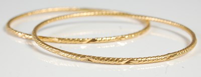 Lot 612 - Two yellow metal high carat bangles, tests as...
