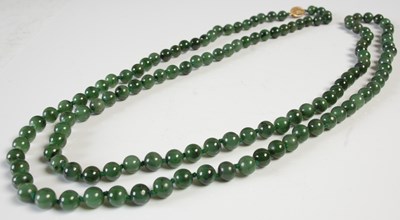Lot 585 - A Chinese green stone ball necklace with...