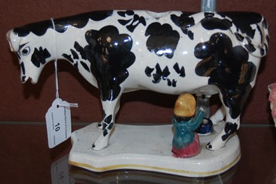Lot 10 - A pottery cow creamer, with black markings,...