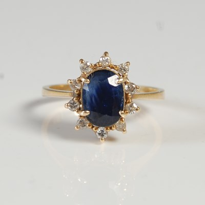 Lot 76 - A yellow metal, sapphire and diamond chip...