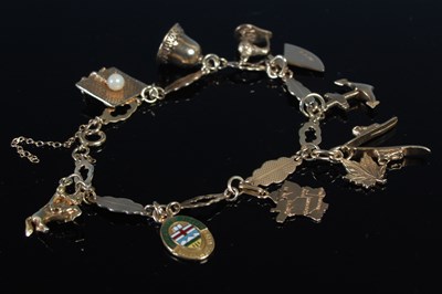 Lot 372 - A 9ct gold charm bracelet, suspending ten...