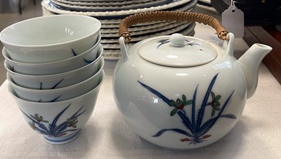 Lot 517 - A Japanese porcelain tea kettle with wicker...