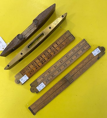 Lot 587 - Three folding rulers and two vintage spirit...