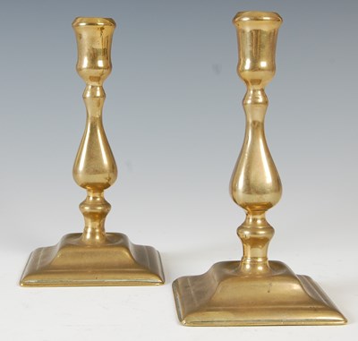 Lot 148 - A pair of antique brass candlesticks, the...