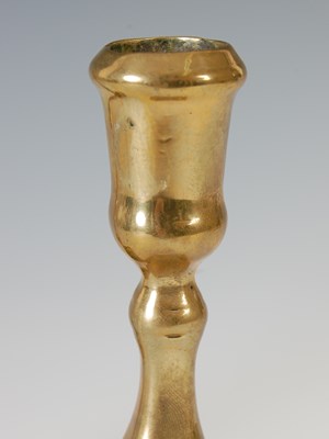 Lot 148 - A pair of antique brass candlesticks, the...