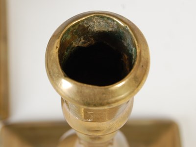 Lot 148 - A pair of antique brass candlesticks, the...