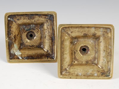 Lot 148 - A pair of antique brass candlesticks, the...