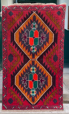Lot 875 - A Baluchi rug, decorated with two lozenge...