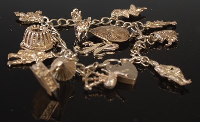 Lot 46 - A white metal charm bracelet, suspending nine...
