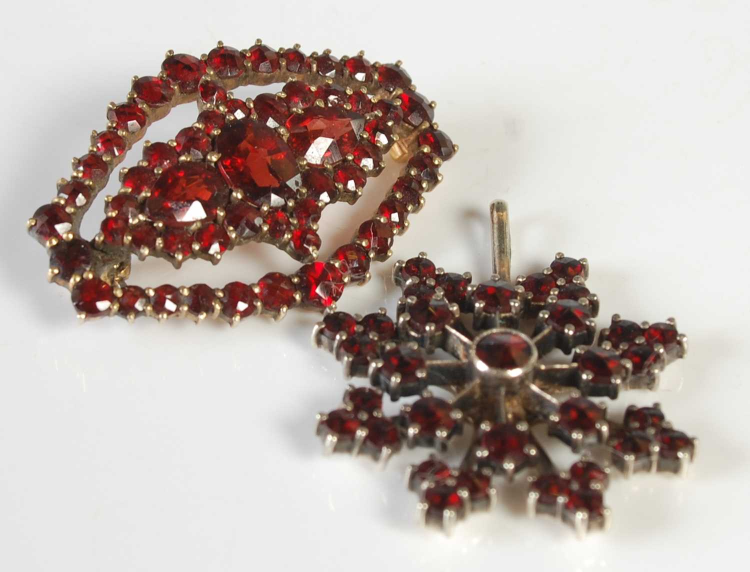 Lot 57 - A vintage yellow metal and garnet oval brooch,...
