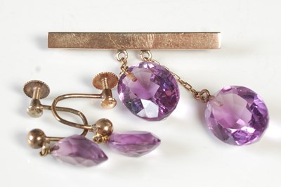 Lot 77 - A yellow metal and amethyst drop bar brooch,...