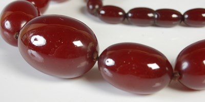 Lot 95 - A red amber type graduated bead necklace,...