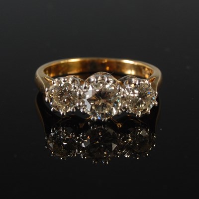 Lot 73 - A yellow and white metal three stone diamond...