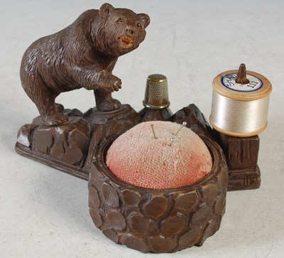 Lot 209 - A Black Forest carved wood sewing companion,...