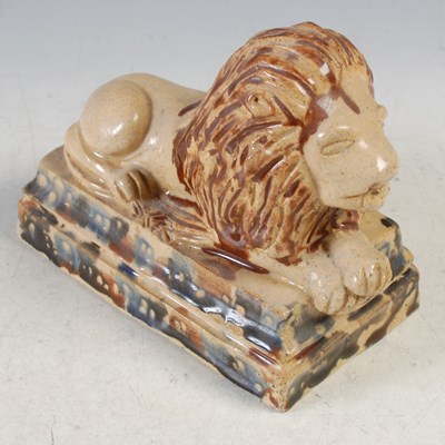 Lot 331 - An Antique pottery model of a recumbant lion...