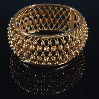 Lot 255 - A yellow metal hinged bracelet of convex form,...