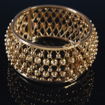 Lot 255 - A yellow metal hinged bracelet of convex form,...