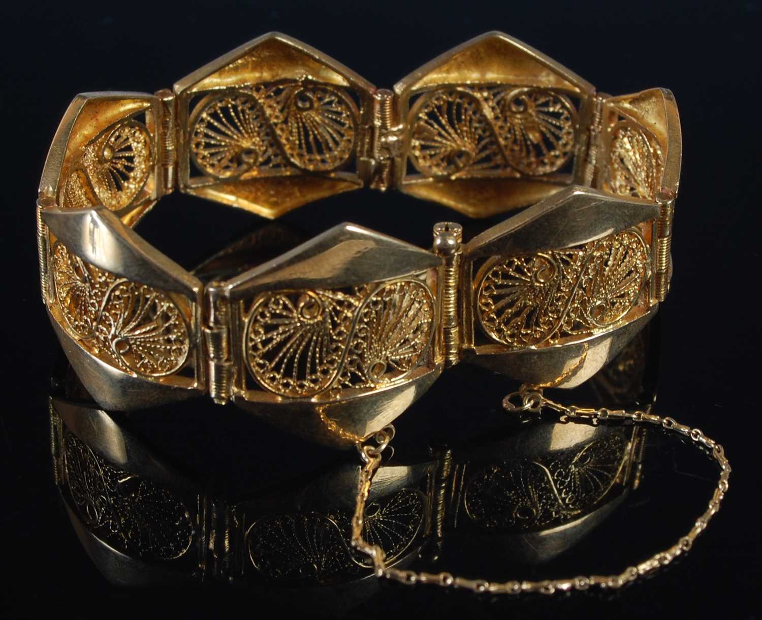 Lot 256 - A yellow metal seven panel bracelet, each...
