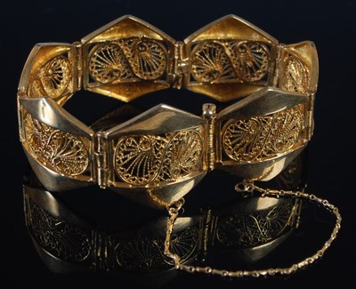 Lot 256 - A yellow metal seven panel bracelet, each...