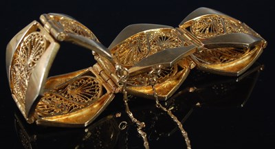 Lot 256 - A yellow metal seven panel bracelet, each...