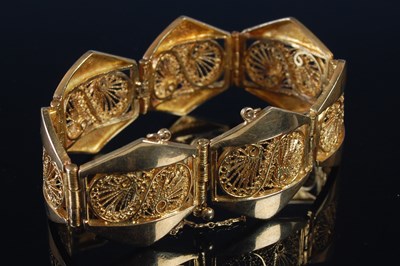 Lot 256 - A yellow metal seven panel bracelet, each...