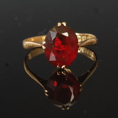 Lot 204F - An 18ct gold and garnet single stone ring,...