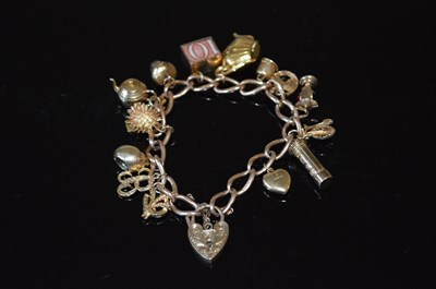 Lot 50B - A 9ct gold charm bracelet, suspending 15...