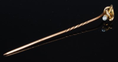 Lot 223 - A gold and pearl tie pin, of entwined loop...