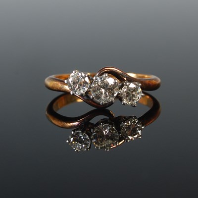 Lot 73 - A white and yellow metal three stone diamond...