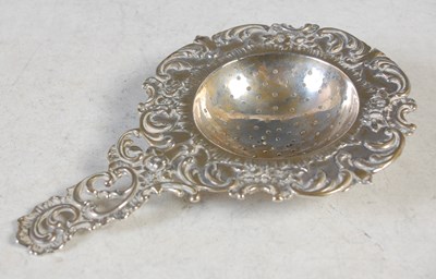 Lot 136 - A Continental white metal tea strainer,...