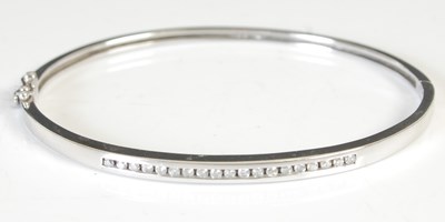 Lot 296B - A white metal and diamond set hinged bangle,...