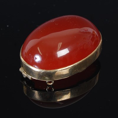 Lot 303A - A yellow metal mounted oval carnelian cabochon...