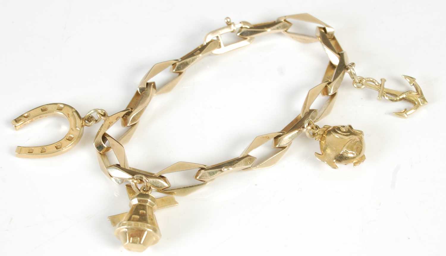 Lot 305 - A 14ct gold charm bracelet suspending four...