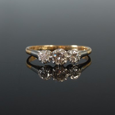 Lot 28 - A yellow and white metal three stone diamond...
