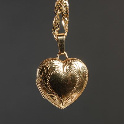 Lot 64 - A 9ct gold heart shaped pendant suspended on...