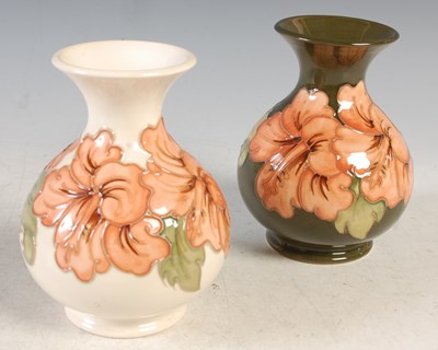 Lot 144 - Two similar Moorcroft Pottery vases, one green...