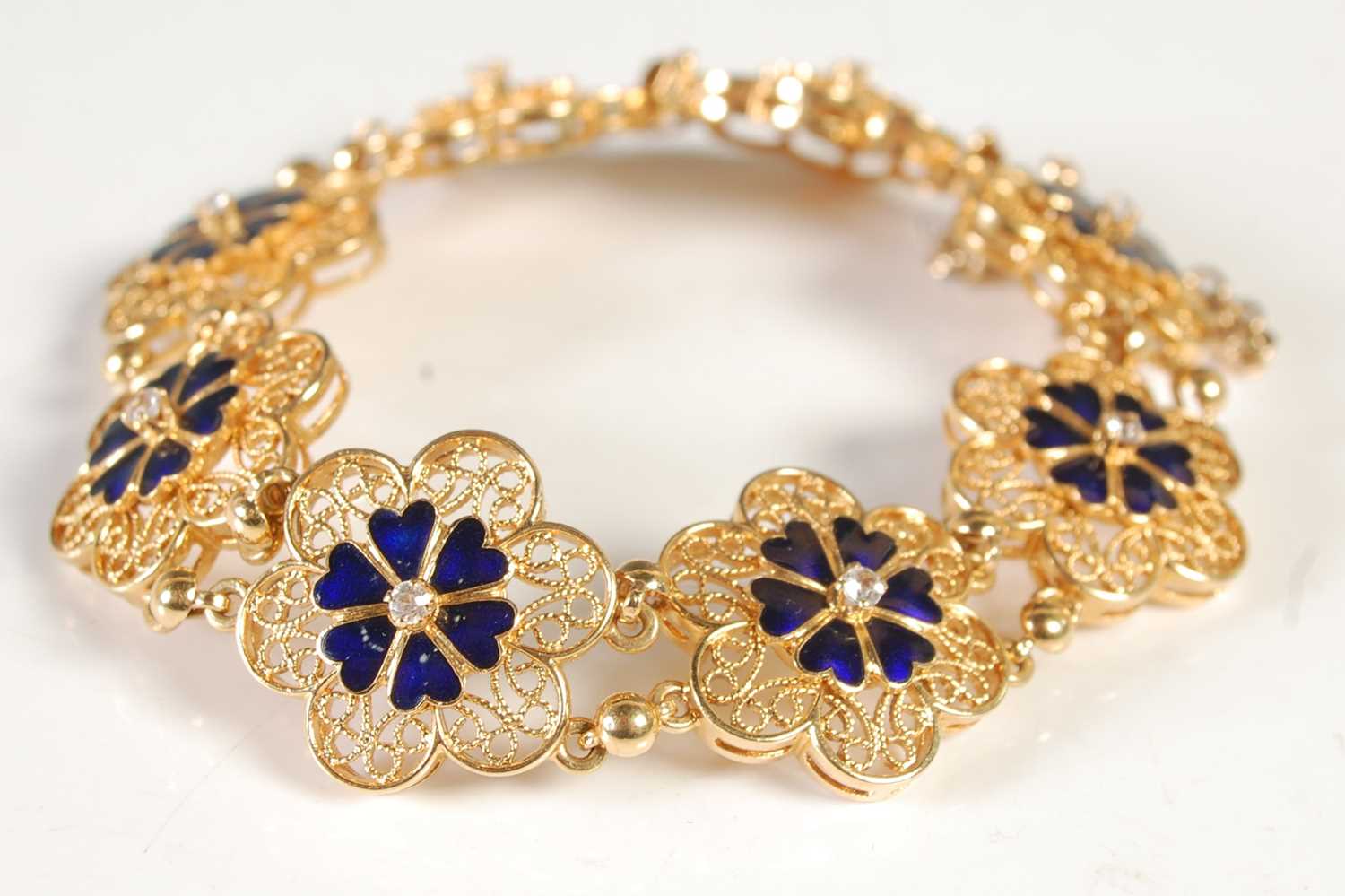 Lot 203 - A yellow metal, blue enamel and diamond set...