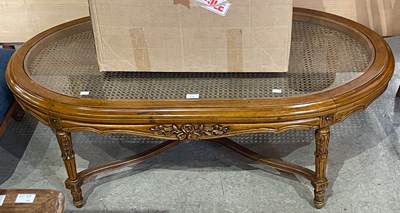 Lot 635 - A stained wood oval coffee table, with glass...
