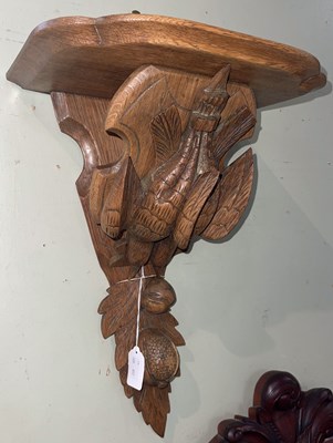 Lot 598 - A blonde wood wall bracket carved with a pair...
