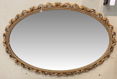 Lot 683 - A giltwood oval wall mirror with scroll frame,...