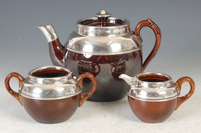 Lot 19 - A George V silver-mounted pottery three piece...