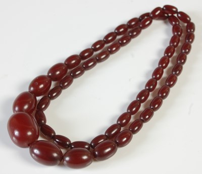 Lot 288 - A graduated red amber type bead necklace, 52.4...