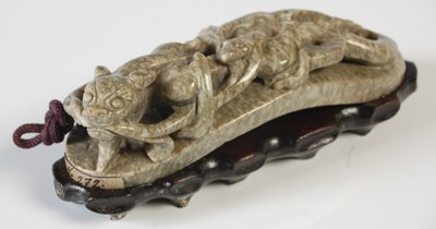 Lot 388 - A Chinese green stone belt hook, carved with...