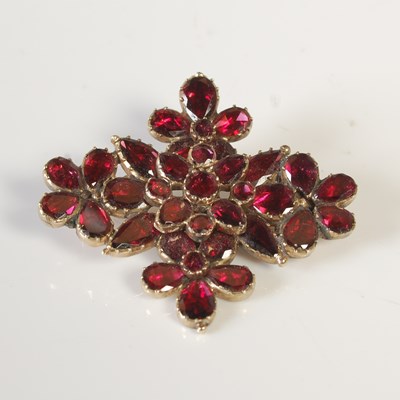 Lot 472 - A yellow metal and garnet set flower brooch,...