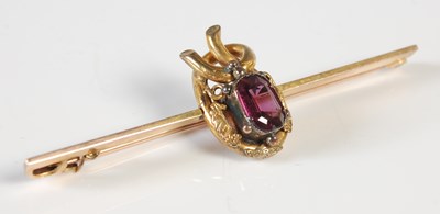 Lot 473 - A yellow metal and purple gemstone set bar...