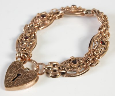Lot 484 - A yellow metal and garnet set panel bracelet...
