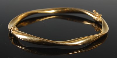 Lot 442 - A 9ct gold hinged bangle, with sprung action,...